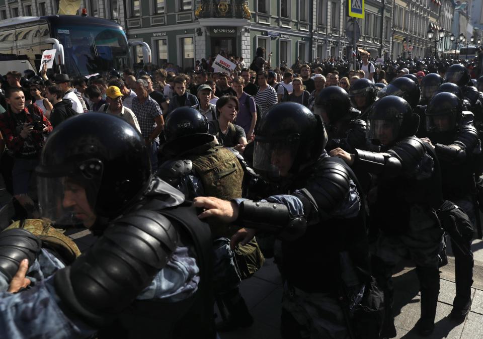 Police block a street during an unsanctioned rally in the center of Moscow, Russia, Saturday, July 27, 2019. Russian police clashed with demonstrators and have arrested some hundreds in central Moscow during a protest demanding that opposition candidates be allowed to run for the Moscow city council. (AP Photo/ Pavel Golovkin)