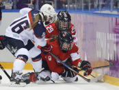 Lauriane Rougeau (5) and Marie-Philip Poulin of Canada (29) fight for the puck against Lyndsey Fry of the United States (18) during the second period of the women's gold medal ice hockey game at the 2014 Winter Olympics, Thursday, Feb. 20, 2014, in Sochi, Russia. (AP Photo/Matt Slocum)