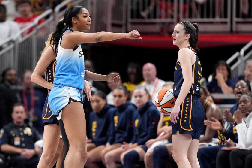 Angel Reese reacts after fouling Caitlin Clark, who looks on