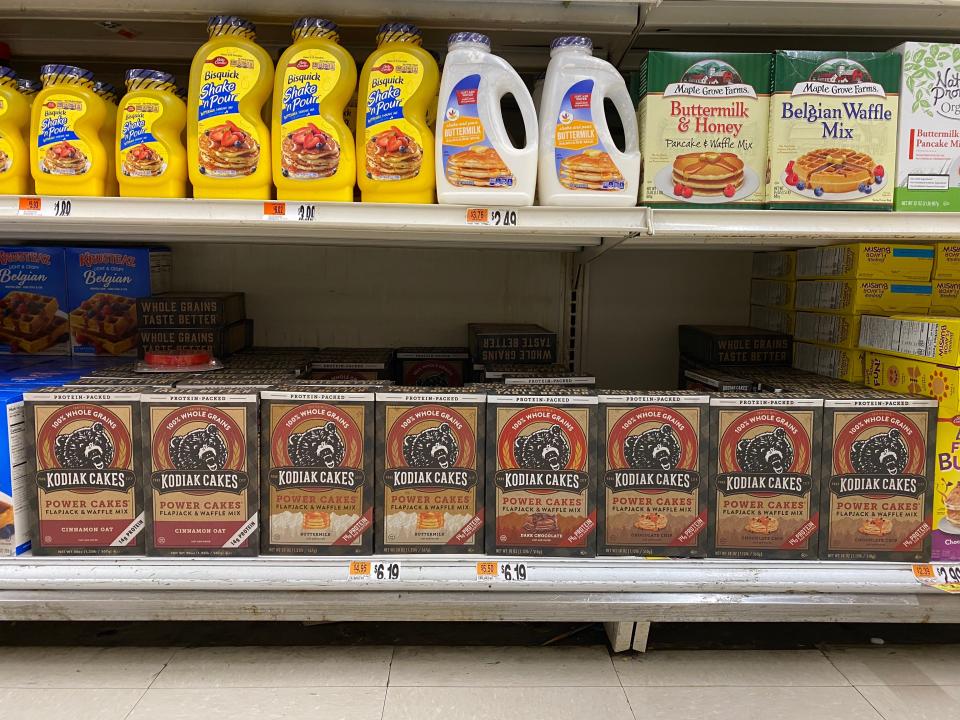 Kodiak pancakes on the shelves in a grocery store surrounded by other pancake mixes