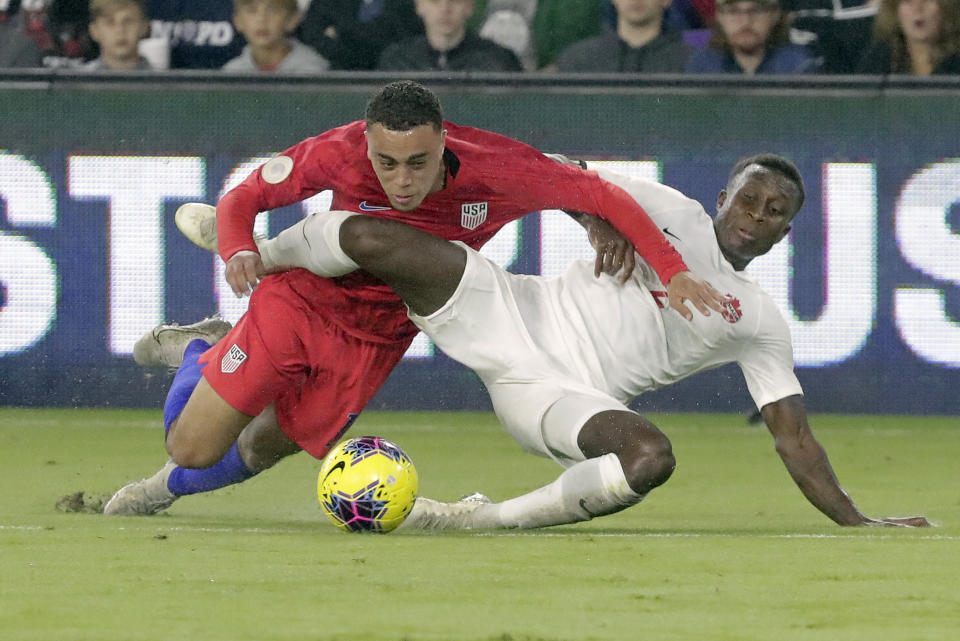 U.S. defender Sergino Dest, left, gets tangled up with Canada defender Richie Laryea while going after the ball during the first half of a CONCACAF Nations League soccer match Friday, Nov. 15, 2019, in Orlando, Fla. (AP Photo/John Raoux)