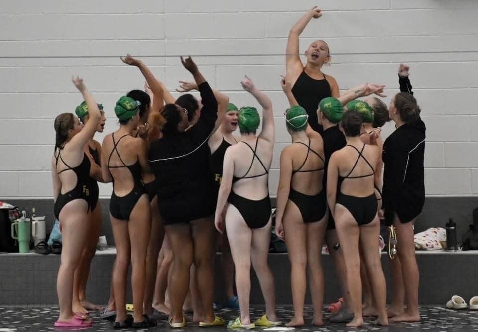 Lauren McNamara leads Flat Rock's girls swimming team in a cheer.