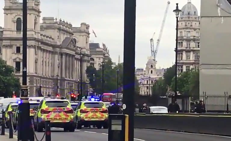 A videograb posted by Twitter user @EwelinaUO shows armed police surrounding a silver car after it crashed into barriers outside the Houses of Parliament on August 14, 2018 in central London