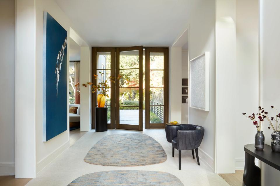 Bright and light is the theme in the entryway, which houses a large painting by Tauba Auerbach; two custom hand-knotted area rugs by Marc Phillips, a Souffle Cocktail Chair by Kelly Wearstler, Infinity Nets (ABCDQ) by Yayoi Kusama, a custom plinth by Legaspi Courts Design, and a Guaxs Vase in Amber Cubistic Glass from Table Art. The art advisor for Lau’s home was Kimberly Chang Mathieu of KCM Fine Arts.
