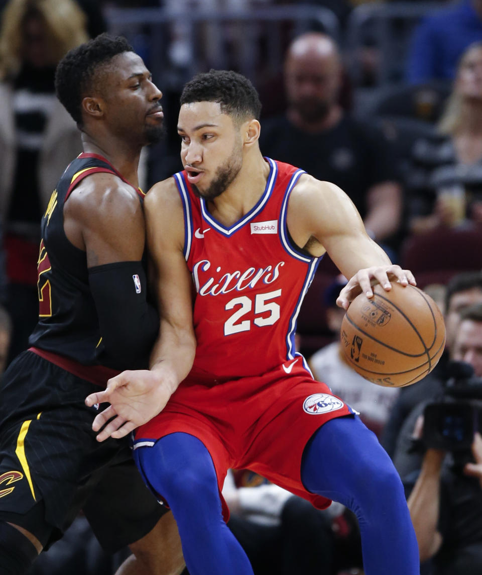 Philadelphia 76ers' Ben Simmons (25), from Australia, tries to drive against Cleveland Cavaliers' David Nwaba, left, during the first half of an NBA basketball game Sunday, Dec. 16, 2018, in Cleveland. (AP Photo/Ron Schwane)