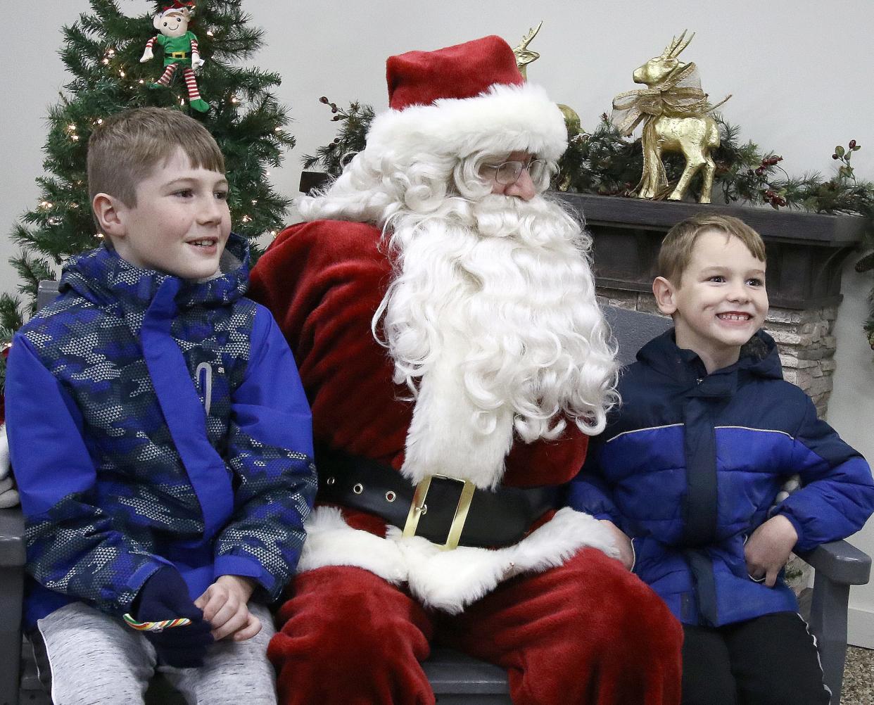 Chance Smith, 10, left, and his brother, Giovanni James, 6, right, visited with Santa Saturday, Dec. 3, 2022, during Christmas in the Park  at Silver Park.