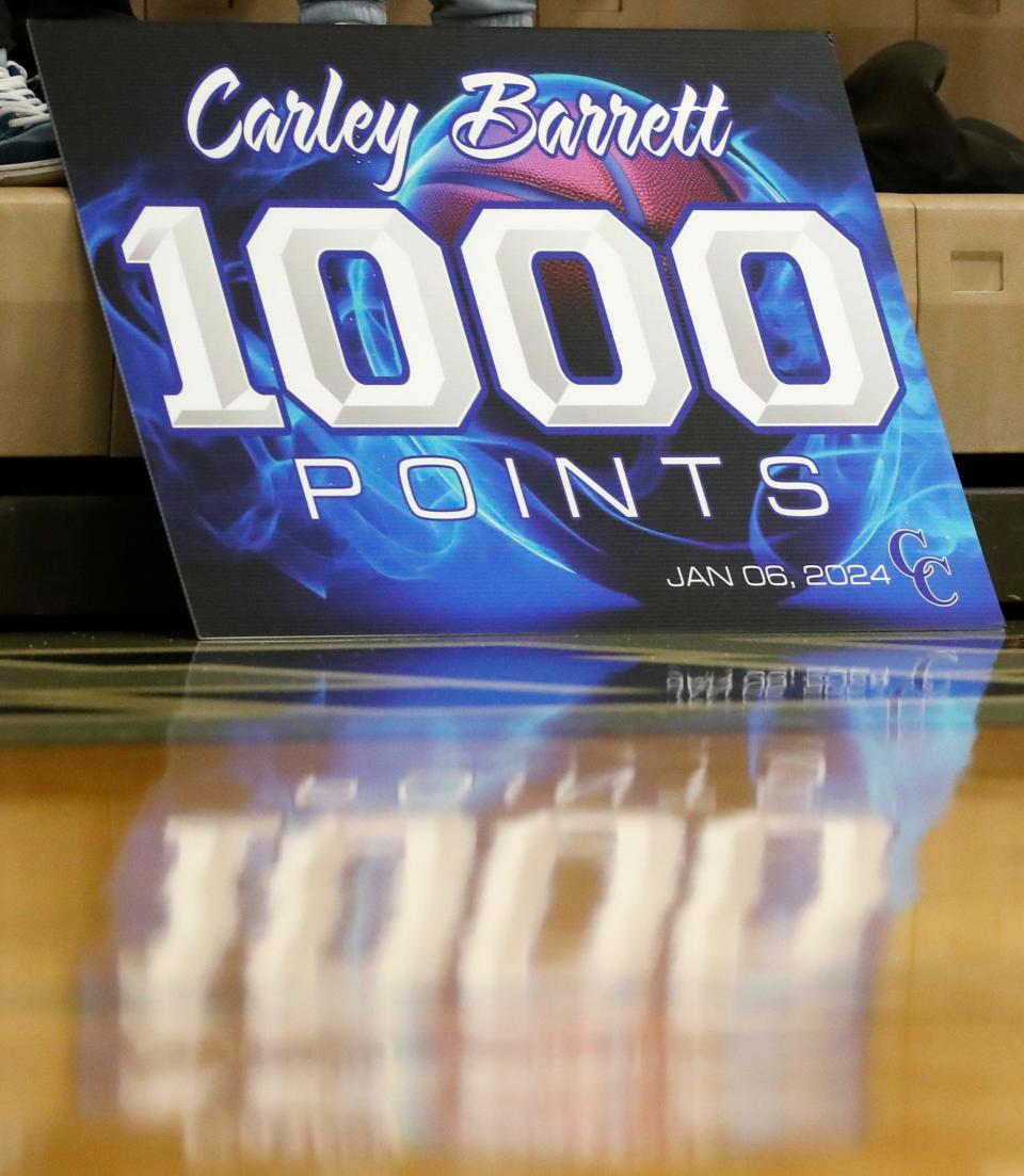 A sign is brought honoring Central Catholic Knights Carley Barrett (24) for reaching 1000 career points during the IHSAA girl’s basketball game against the West Lafayette Red Devils, Tuesday, Jan. 9, 2024, at Central Catholic High School in Lafayette, Ind. Central Catholic won 64-56.