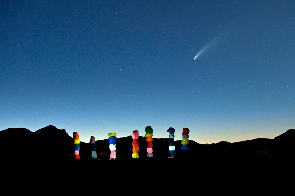 Comet Neowise is seen in the sky, above the "Seven Magic Mountains" art installation by artist Ugo Rondinone, in Jean, Nevada on July 15, 2020.