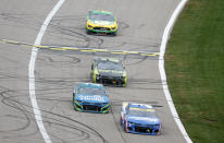 Kyle Larson (5) leads Kurt Busch (1), William Byron (24) and Kevin Harvick (4) during a NASCAR Cup Series auto race at Kansas Speedway in Kansas City, Kan., Sunday, Oct. 24, 2021. (AP Photo/Colin E. Braley)