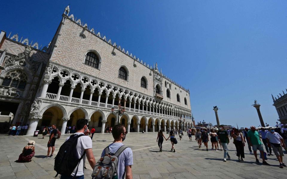 Tourists stroll past the Doge's Palace in Venice - AFP