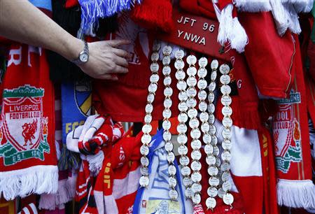 A fan looks at tributes on the Shankly gates before a memorial service to mark the 25th anniversary of the Hillsborough disaster at Anfield in Liverpool, northern England April 15, 2014. REUTERS/Darren Staples