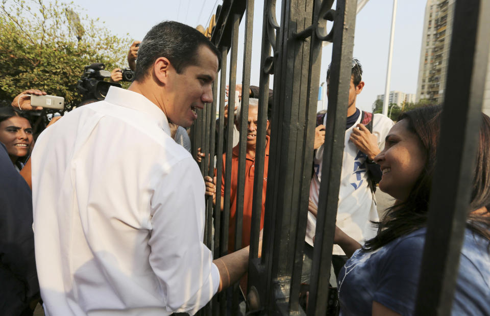 El dirigente opositor venezolano Juan Guaidó, izquierda, saluda a sus seguidores en la iglesia de Chiquinquirá, Maracaibo, Venezuela, el sábado 13 de abril de 2019. (AP Foto/Fernando Llano)