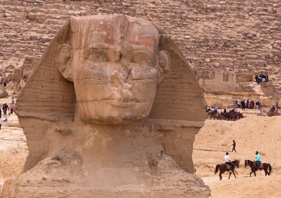Visitors enjoy horse rides near the ancient statue of Sphinx, with the body of a lion and a human head, at the historic site of Giza Pyramids in Cairo, Egypt, Friday, Jan. 26, 2018 .