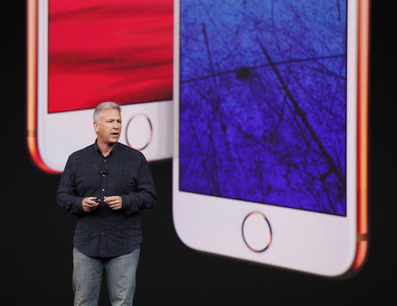 Apple executive Phil Schiller in front of an image of Apple's iPhone 8 and iPhone 8 Plus.