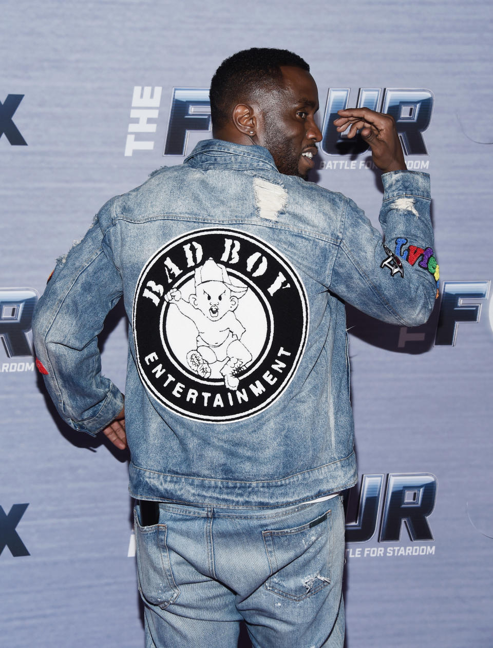 Combs shows off a denim jacket with the logo of Bad Boy Entertainment on the back.