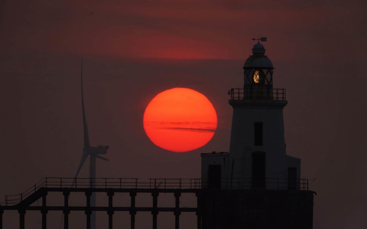 The sunrise over Blyth East Pier Lighthouse in Northumberland followed another sweltering night -  Owen Humphreys/PA