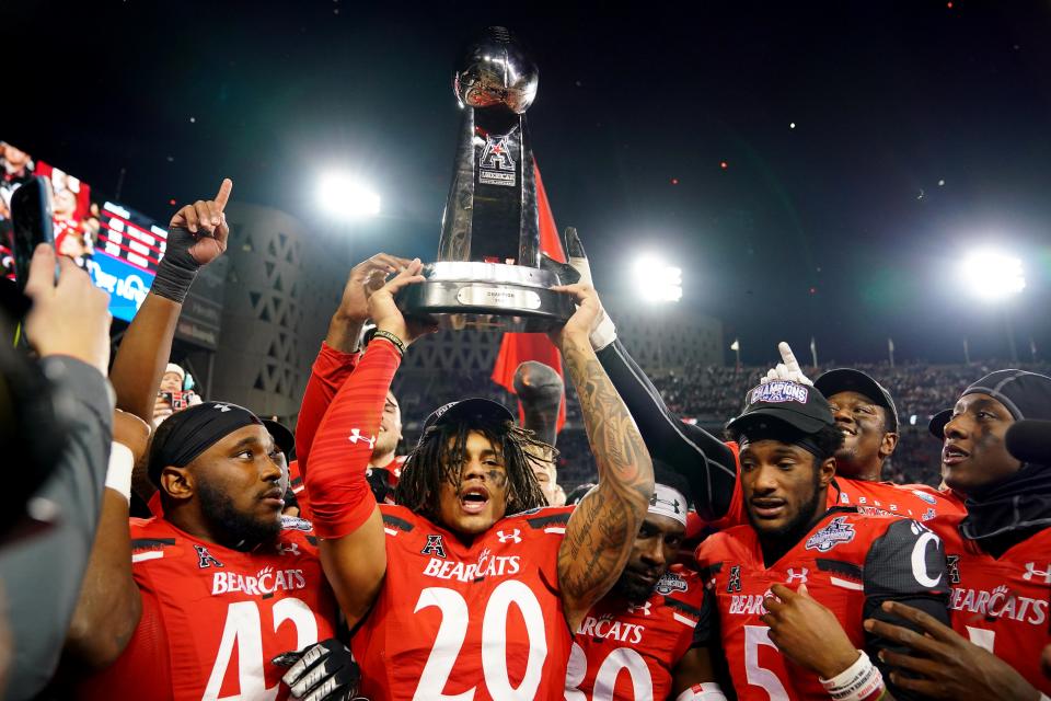 Cincinnati Bearcats linebacker Deshawn Pace (20) raises the trophy of the American Athletic Conference championship football game, Saturday, Dec. 4, 2021, at Nippert Stadium in Cincinnati. The Cincinnati Bearcats defeated the Houston Cougars, 35-20. 