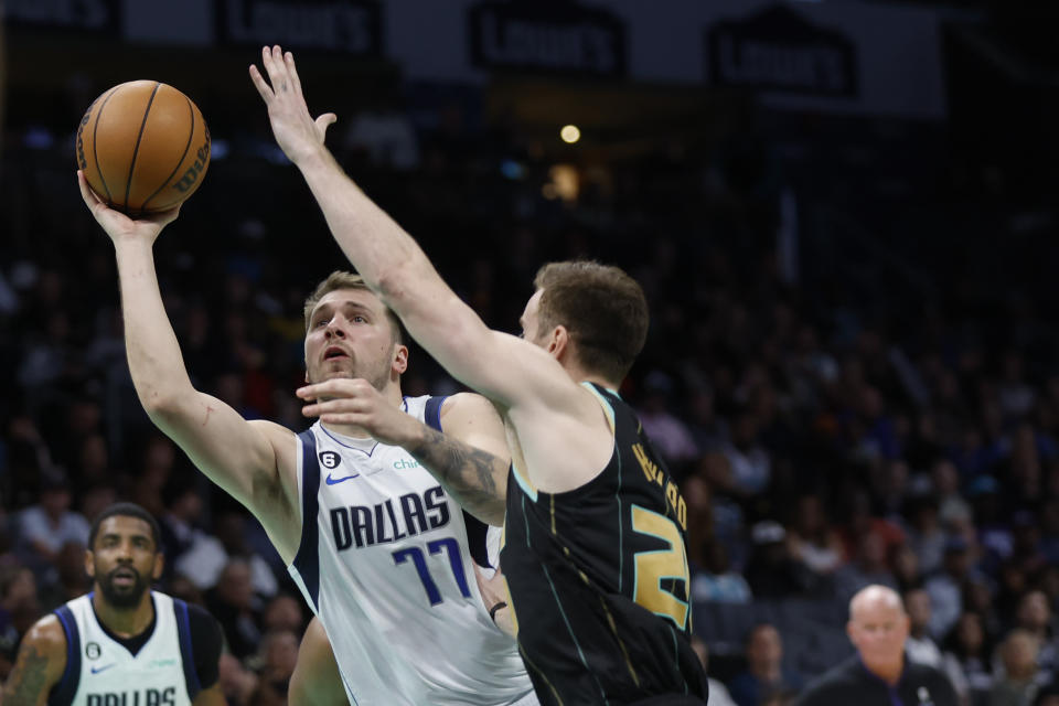 Dallas Mavericks guard Luka Doncic, left, shoots against Charlotte Hornets forward Gordon Hayward during the second half of an NBA basketball game in Charlotte, N.C., Sunday, March 26, 2023. Charlotte won 110-104. (AP Photo/Nell Redmond)