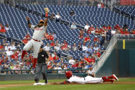 Washington Nationals' Victor Robles, bottom right, safely steals third base in front of Philadelphia Phillies third baseman Maikel Franco in the first inning of a baseball game, Thursday, Sept. 26, 2019, in Washington. (AP Photo/Patrick Semansky)