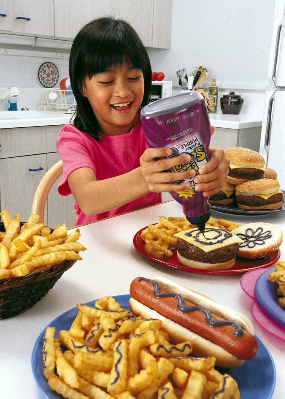 This undated photo shows a girl using Heinz''s new "Funky Purple" ketchup bottle