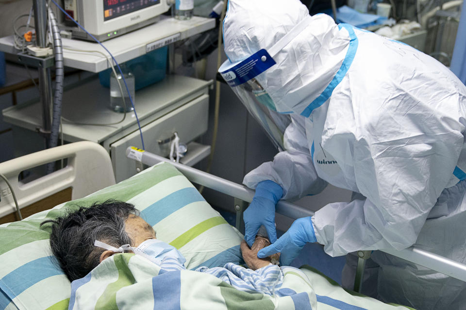 A medical worker attends to a patient in the intensive care unit at Zhongnan Hospital. Source: AP