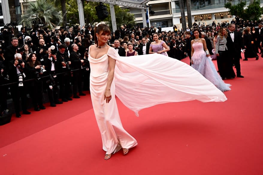 Helena Christensen arriving at the 77th Cannes Film Festival in a white dress