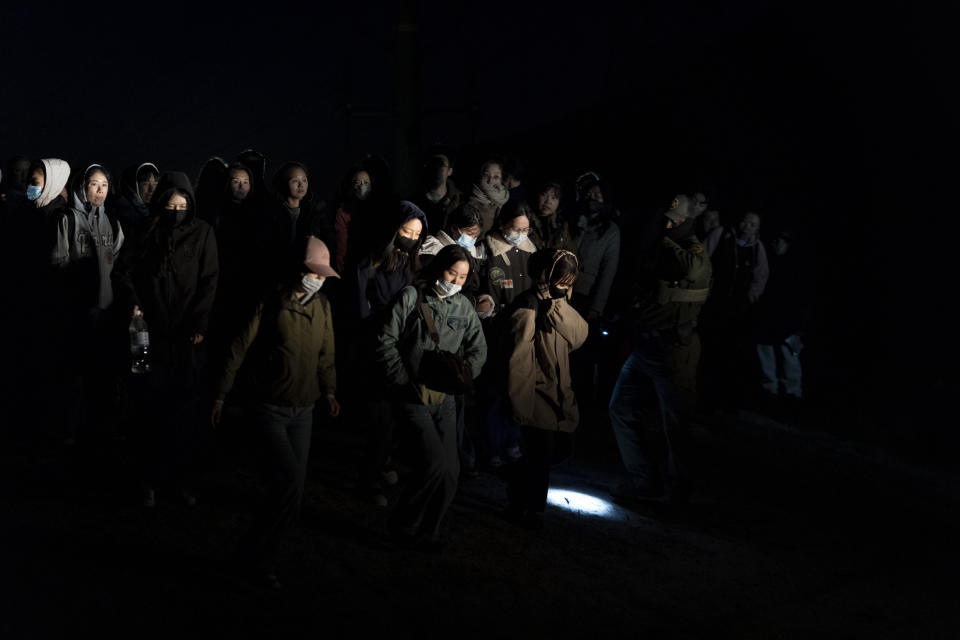 Chinese migrants line up to be loaded onto U.S Border Patrol vehicles to apply for asylum Wednesday, May 8, 2024, near Jacumba Hot Springs, Calif. San Diego became the busiest corridor for illegal crossings in April, according to U.S. figures, the fifth region to hold that title in two years in a sign of how quickly migration routes are changing. (AP Photo/Ryan Sun)