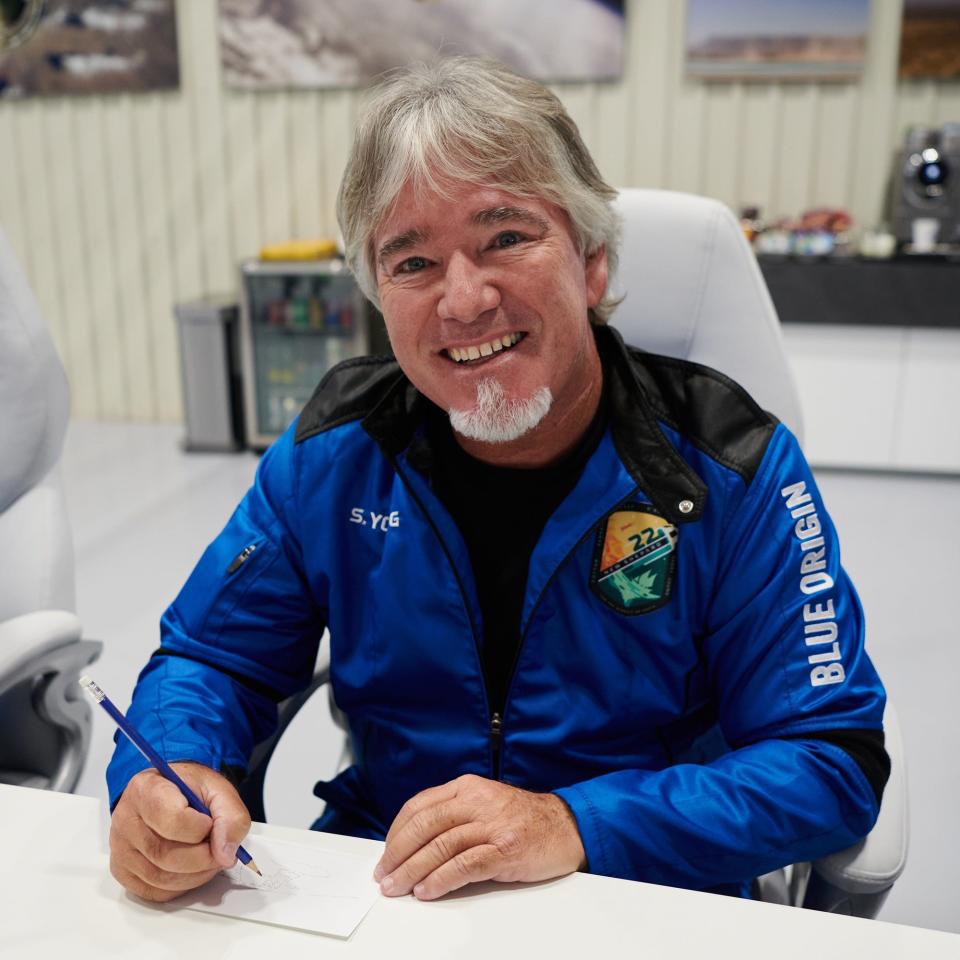 Steve Young fills out a postcard Wednesday that he took into space aboard Blue Origin's New Shepard NS-22 mission.