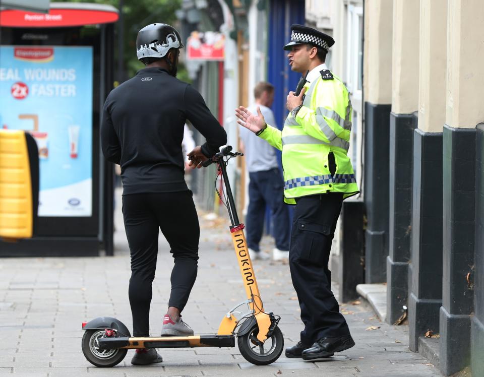 An officer speaks to a member of the public riding an e-scooter (PA Archive)