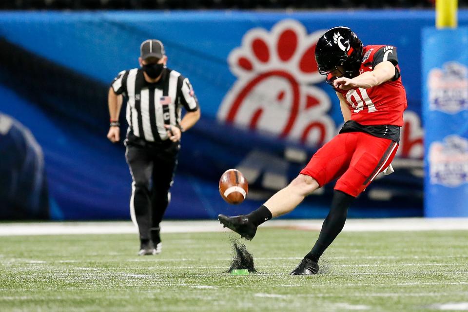 Cincinnati Bearcats place kicker Alex Bales (91) kicks off after a UC touchdown in the first quarter of the Chick-fil-a Peach Bowl at Mercedes-Benz Stadium in Atlanta on Friday, Jan. 1, 2021. The Bearcats led 14-10 at halftime. 