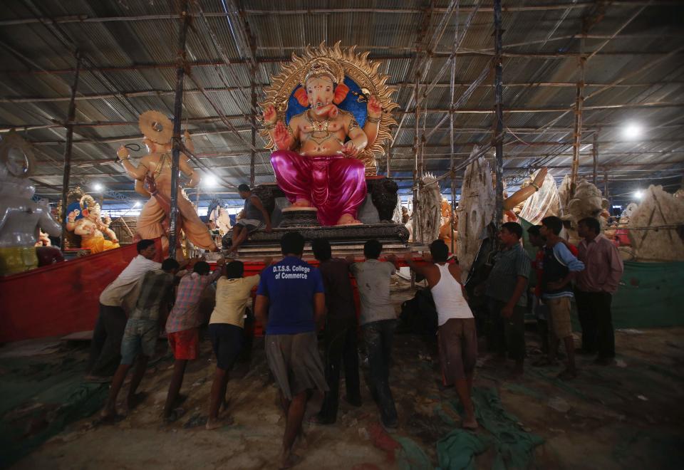 Workers push a trolley with an idol of Hindu elephant god Ganesh, the deity of prosperity, as it is transported from a workshop to a place of worship in Mumbai