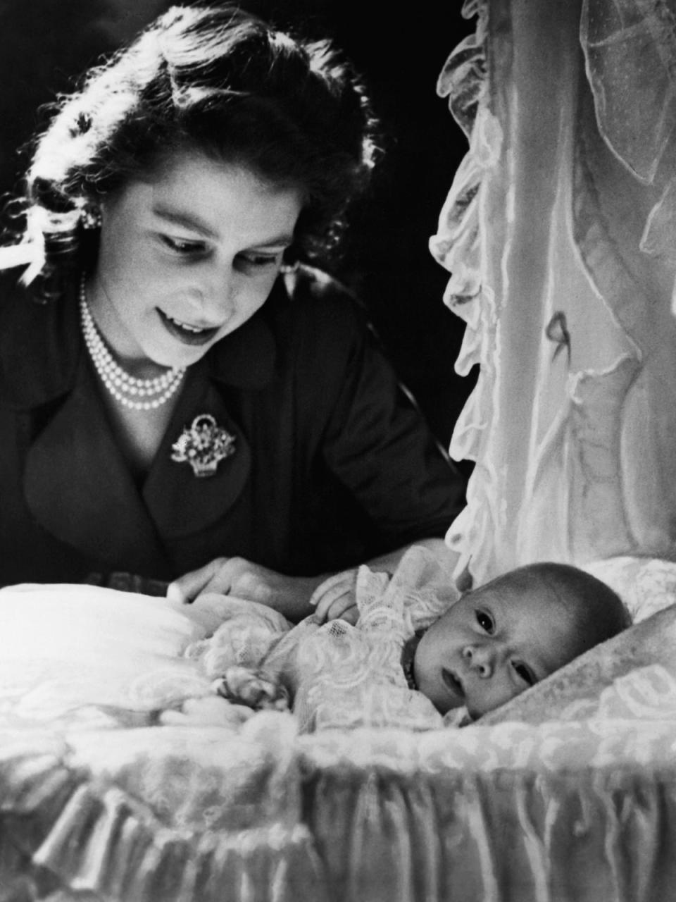 Elizabeth smiles at her first child, a month-old Prince Charles who was born on 14 November, 1948 (Corbis/Getty)