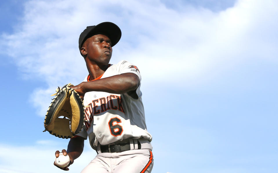 Frederick Keys catcher Dennis Kasumba warms up before the team's baseball game against the Trenton Thunder, Tuesday, July 4, 2023, in Trenton, N.J. Kasumba, from Uganda, dreams of reaching the major leagues someday. The 19-year-old catcher had a chance to play for the Frederick Keys of the MLB Draft League this past month. (AP Photo/Noah K. Murray)