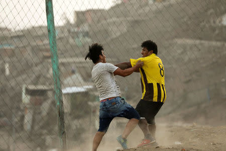 Men playing soccer have a fight during a game at a makeshift soccer field in Nueva Union shantytown in Villa Maria del Triunfo district of Lima, Peru, May 27, 2018. REUTERS/Mariana Bazo