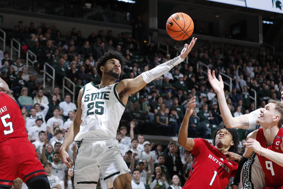 Michigan State forward Malik Hall (25) and Rutgers guard Jamichael Davis (1) and Rutgers forward Oskar Palmquist (9) reach for a rebound during the first half of an NCAA college basketball game, Sunday, Jan. 14, 2024, in East Lansing, Mich. (AP Photo/Al Goldis)