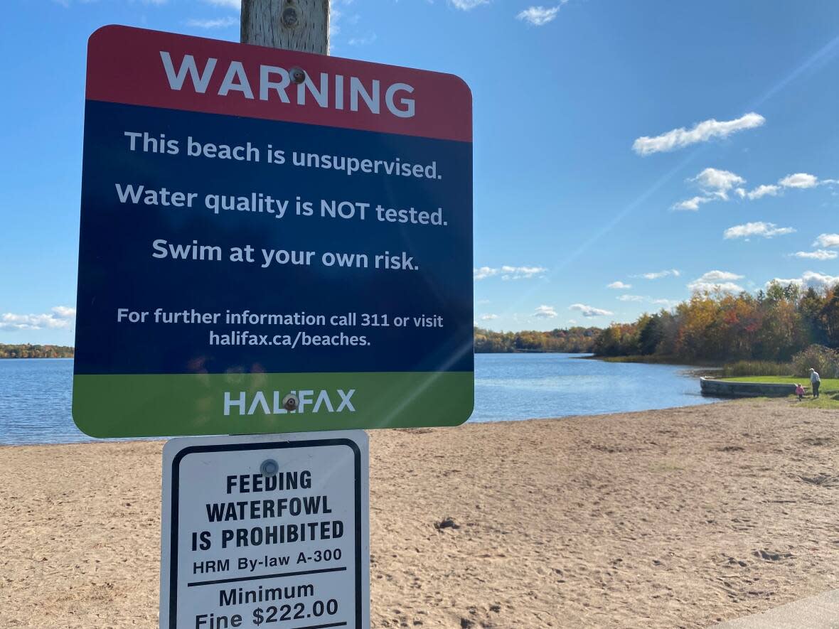 A sign warns people that Kinsmen Beach at First Lake in Lower Sackville, N.S., is unsupervised and the water quality is not tested. (Brian MacKay/CBC - image credit)