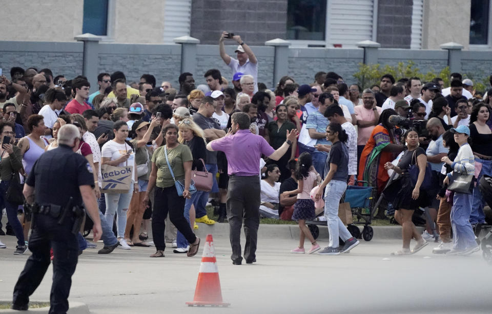 Personas se reúnen del otro lado de la calle de un centro comercial tras un tiroteo el sábado 6 de mayo de 2023 en Allen, Texas. (AP Foto/LM Otero)