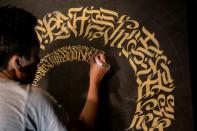 With deliberate golden strokes, artist Taipan Lucero proudly brings an ancient script back to life, in the hope of promoting an endangered but contentious part of the Philippines' heritage