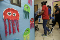 Young migrants are overseen strolled by Comprehensive Health Services caregivers at a "tender-age" facility for babies, children and teens, in Texas' Rio Grande Valley, Thursday, Aug. 29, 2019, in San Benito, Texas. Sheltering migrant children has become a booming business for Comprehensive Health Services, a Florida-based government contractor, as the number of children in government custody has swollen to record levels over the past two years. (AP Photo/Eric Gay)