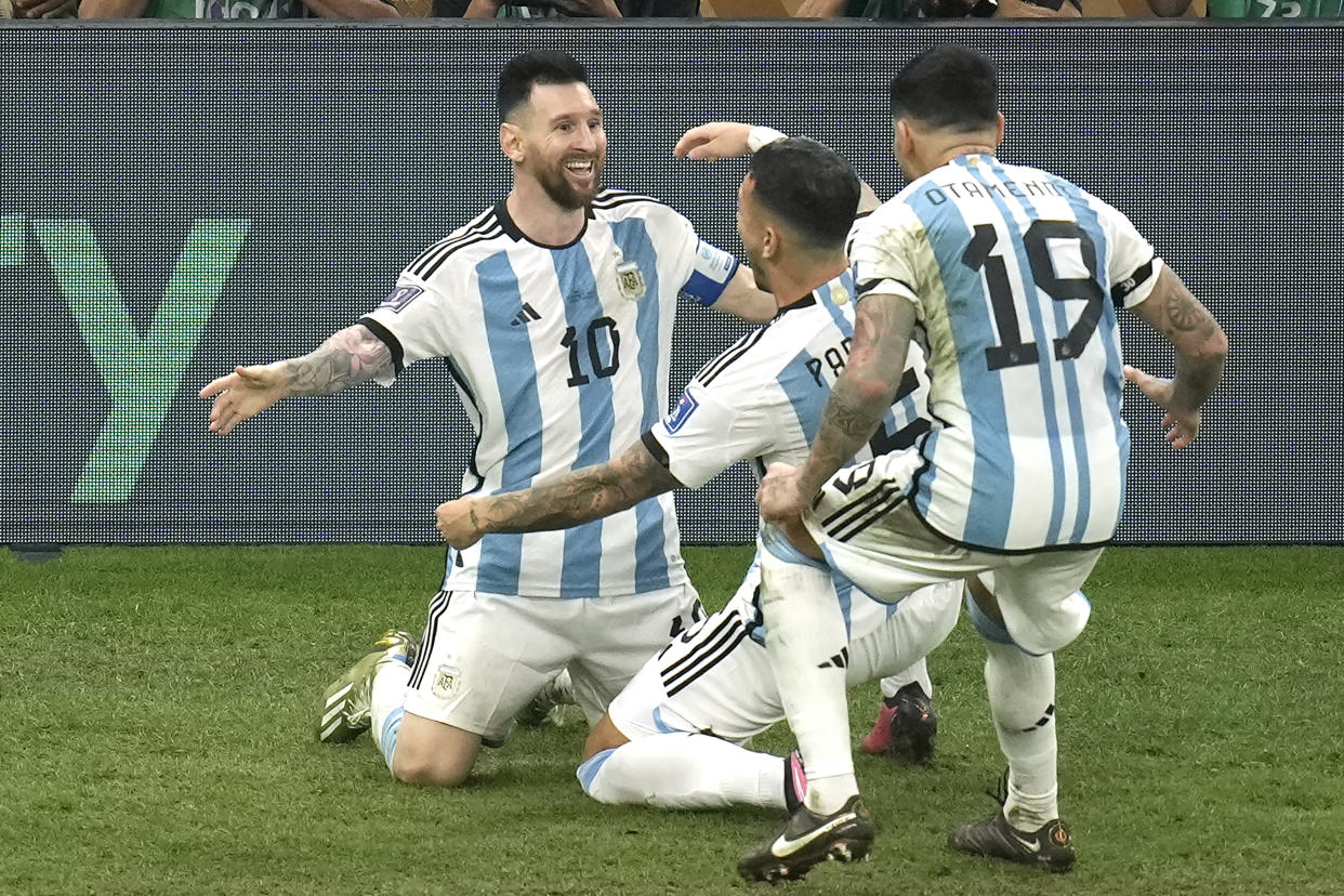 Argentina's Lionel Messi, left, celebrates his side's third goal during the World Cup final soccer match between Argentina and France at the Lusail Stadium in Lusail, Qatar, Sunday, Dec. 18, 2022. (AP Photo/Christophe Ena)