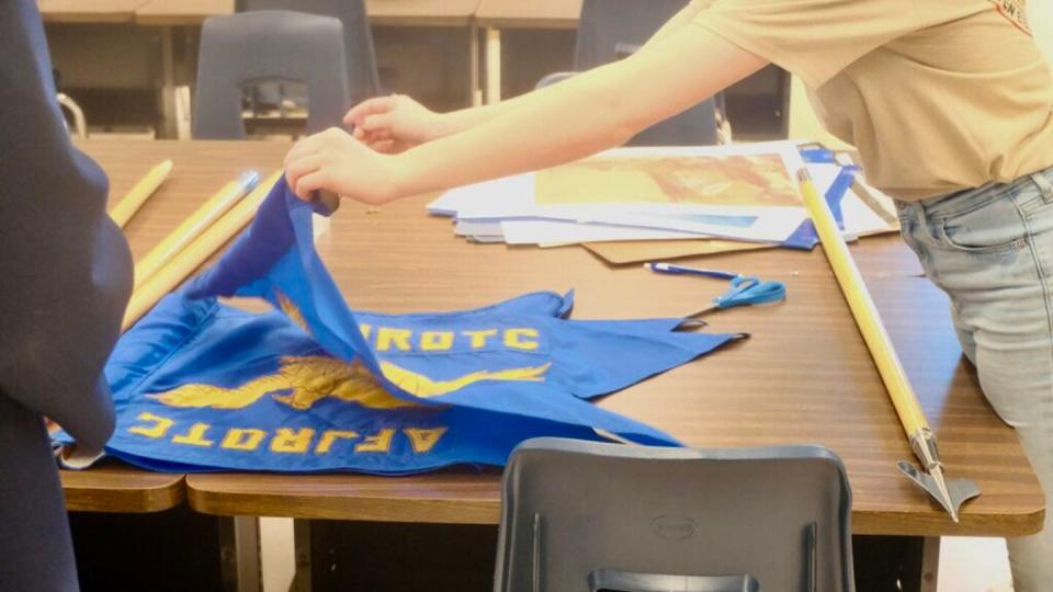 An Air Force JROTC student folds a flag in a Ben Eielson Junior Senior High School classroom on April 22, 2024. (Claire Stremple/Alaska Beacon)