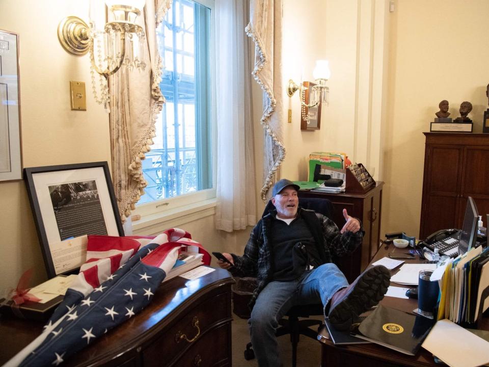 A supporter of then-President Donald Trump sits inside the office of Speaker of the House