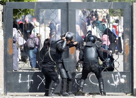 Riot police attempt to break open the entrance of the al-Azhar University Campus during clashes with female university students, who are supporters of the Muslim Brotherhood and ousted Egyptian President Mohamed Mursi, in Cairo's Nasr City district, March 19, 2014. REUTERS/Amr Abdallah Dalsh