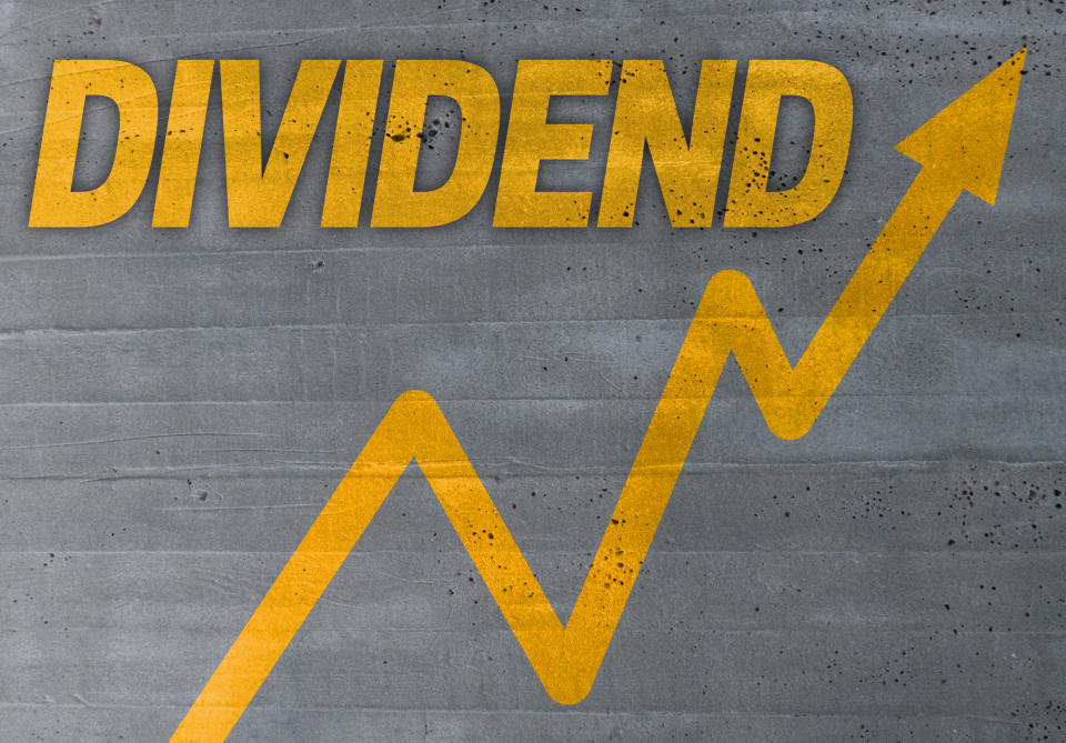 The word dividend in yellow letters written above a yellow arrow going up