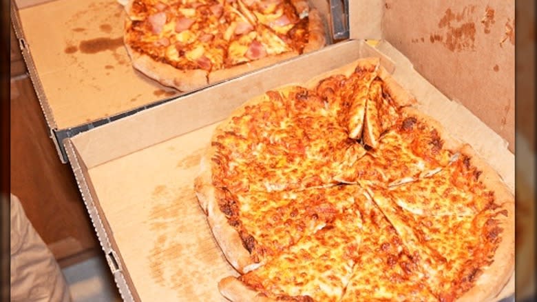 Two damaged takeout pizzas