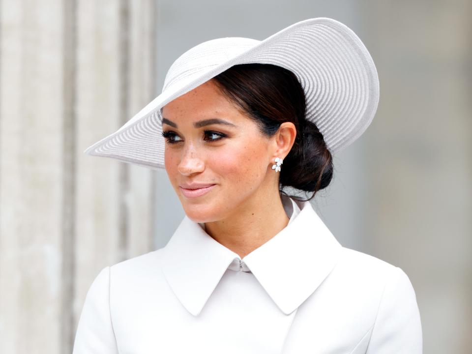 Meghan Markle in a white jacket and hat