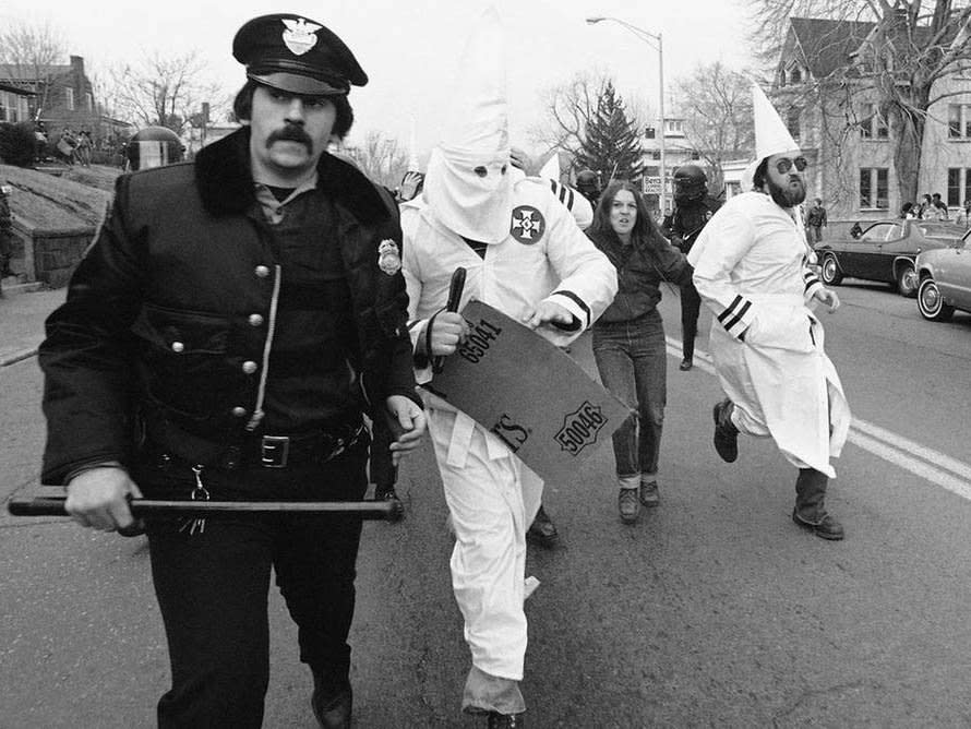 Ku Klux Klan members are escorted away from protesters by police in Meriden, Connecticut, 1981: AP