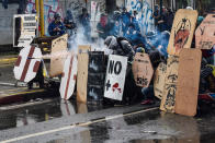 <p>Protesters take cover behind home made shields and throw fireworks at the national guard members during clashes in Caracas, Venezuela on July 28, 2017. (Photo: Carlos Becerra/Anadolu Agency/Getty Images) </p>