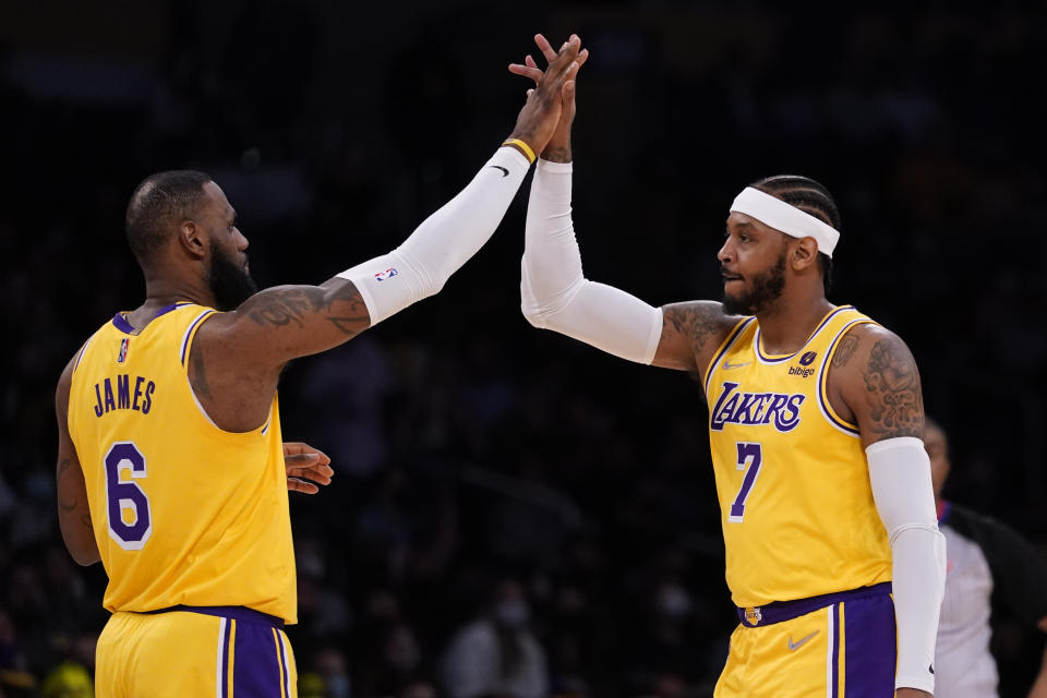 Los Angeles Lakers forward LeBron James (6) high-fives forward Carmelo Anthony (7) during the first half of an NBA basketball game against the Indiana Pacers in Los Angeles, Wednesday, Jan. 19, 2022. (AP Photo/Ashley Landis)