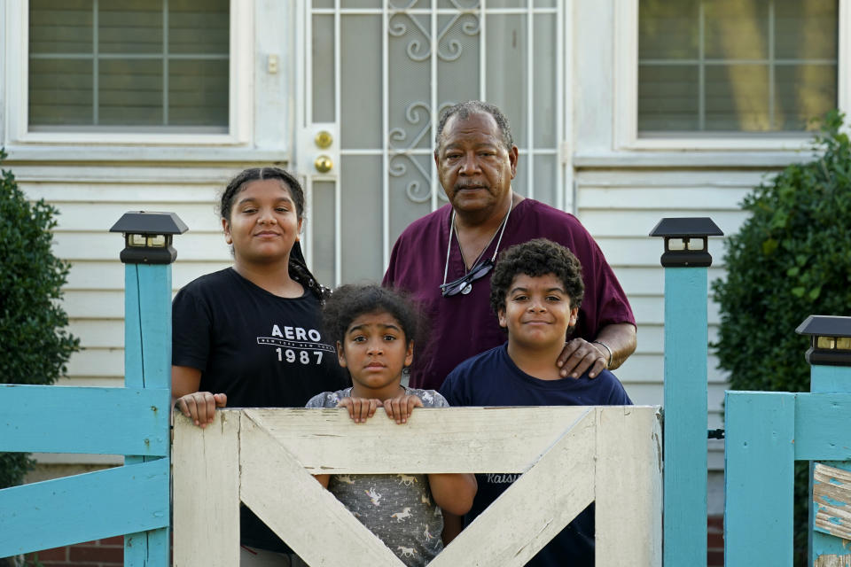 FILE - Angelo Bernard, who lives near the Denka Performance Elastomer Plant, poses with his grandchildren who are visiting him for the weekend, at his home in Reserve, La., on Sept. 23, 2022. From left are Korinne Bernard, 11, Karmen Bernard, 9, and Anthony Bernard, 10, who used to attend Fifth Ward Elementary until Hurricane Ida forced them to move. Federal officials are suing Denka Tuesday, Feb. 28, 2023, alleging that it presented an unacceptable cancer risk to the nearby majority-Black community and demanding cuts in toxic emissions. (AP Photo/Gerald Herbert)